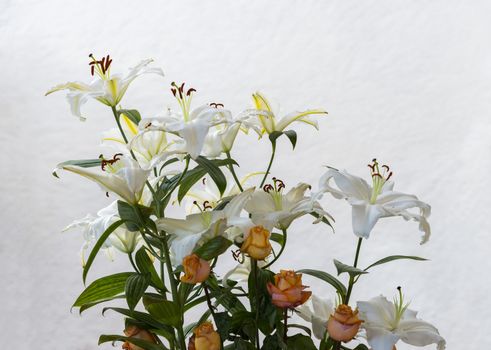 bouquet with white lily and orange roses used for condolence 