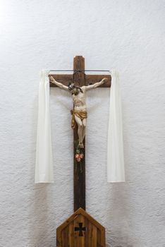 White wall in a church with Jesus Christ on the cross