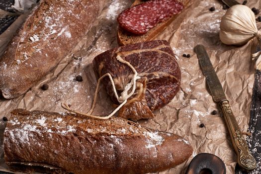 Sausage cooked on the smoke, a large piece and cut into pieces laid out on the bread