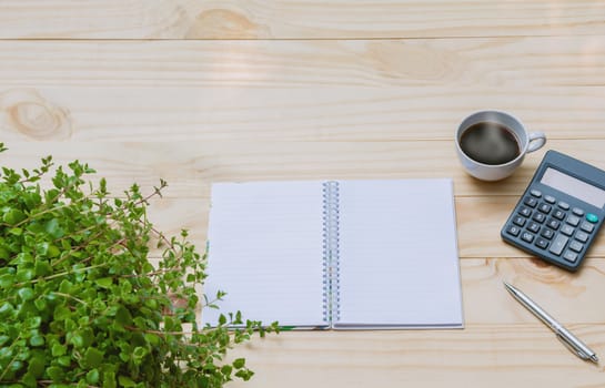 Top view of pen with calculator and notebook on wooden table and copy space for insert text.