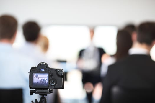 Making video of business people at meeting with photo camera