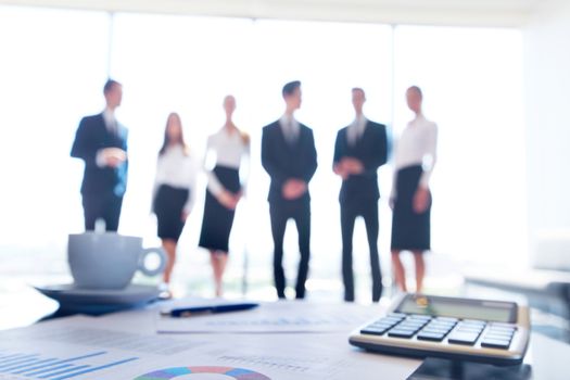 Close up view of printed graphs and business people discussing financial data