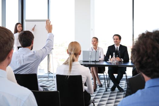 Group of speakers at business meeting at the table with microphones