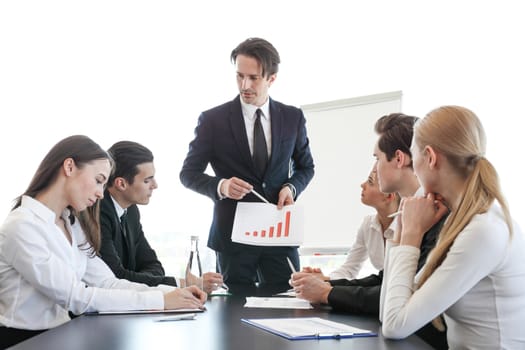 Business man showing financial statistics graph at meeting