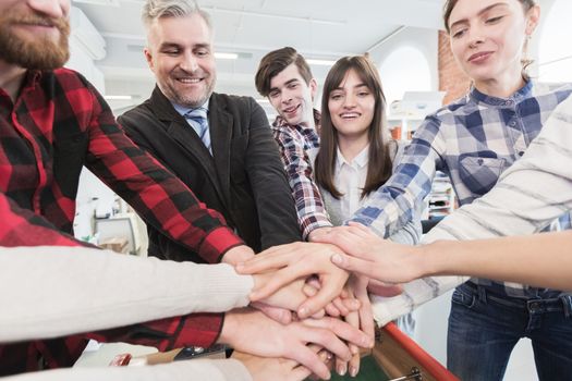 Happy smiling business colleagues stacking hands