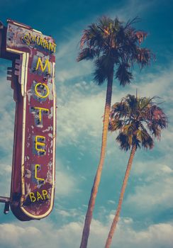 Retro Worn Vintage Neon Motel Sign And Palm Trees