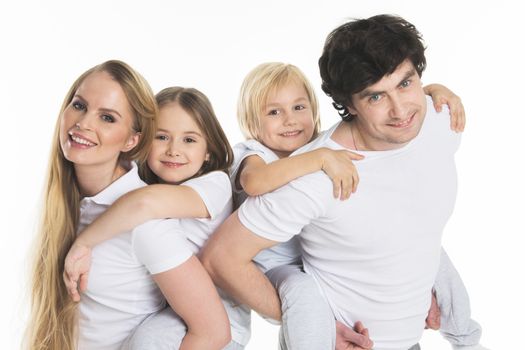Studio portrait of family in white clothes with two children isolated on white background