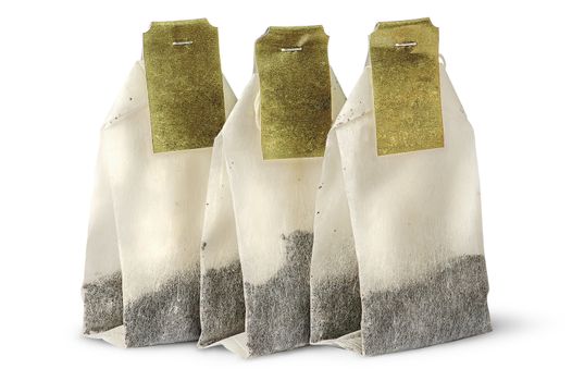 Three tea bags with labels isolated on white background