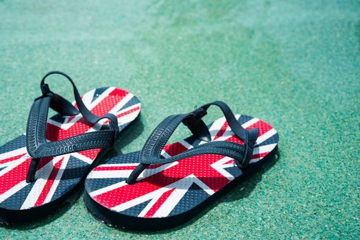 A pair of slippers in pool side at holiday destination