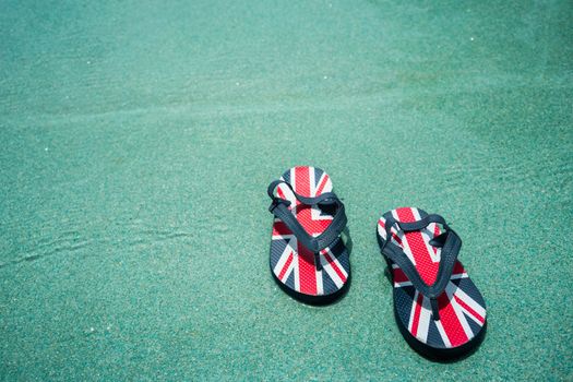 A pair of slippers in pool side at holiday destination