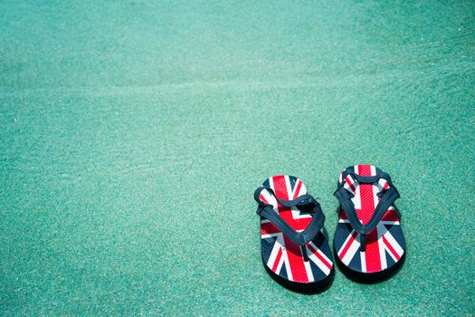 A pair of slippers in pool side at holiday destination