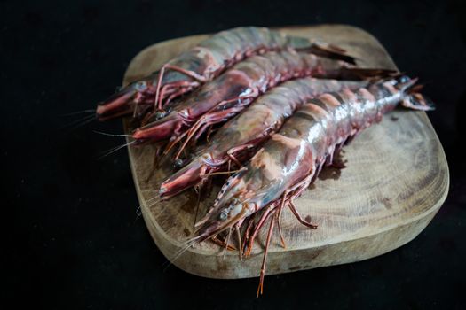 Four large king prawns on a chopping board