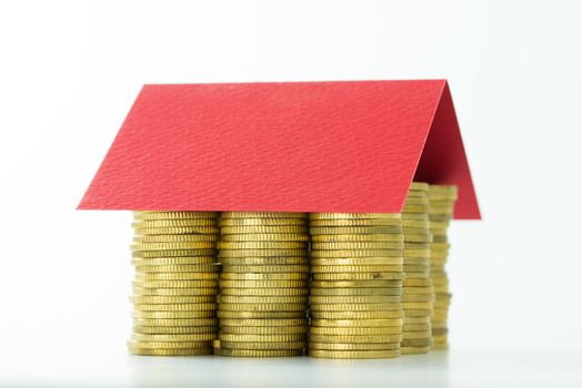 House made from lot of coins and a red color paper roof