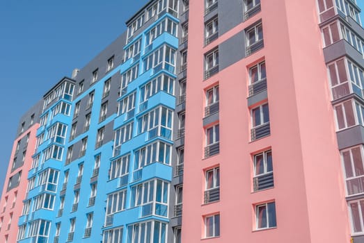 kind of a new multistorey brick residential building with balconies on a sunny day