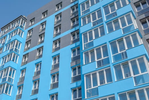 kind of a new multistorey brick residential building with balconies on a sunny day