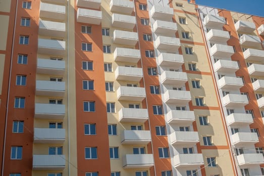 kind of a new multistorey brick residential building with balconies on a sunny day