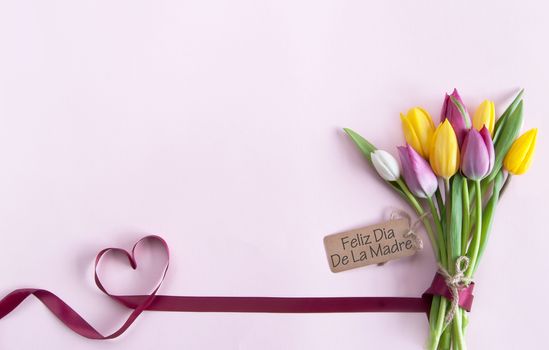 Heart shape ribbon attached to a bunch of flowers with label