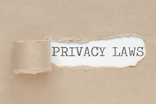 Torn paper revealing the words privacy laws