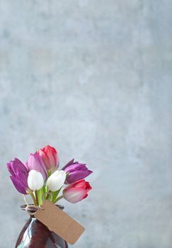 Selection of spring tulips with a gift label and space 