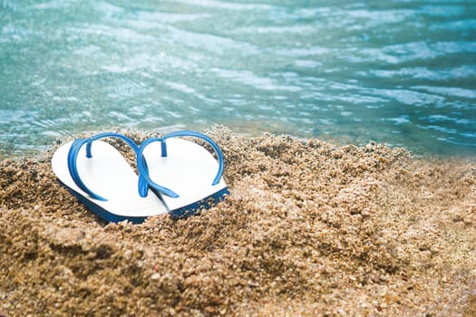 white and blue sandal on the sand beach, Summer holiday and vacation concept.