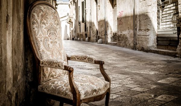 Lecce town, Italy. Vintage chair with old town street in background.