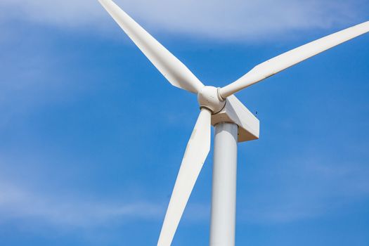 Single Wind Turbine Over Dramatic Blue Sky.