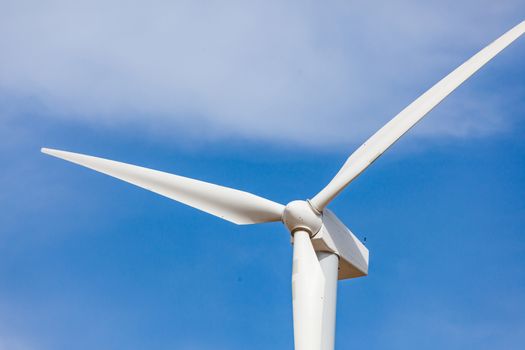 Single Wind Turbine Over Dramatic Blue Sky.