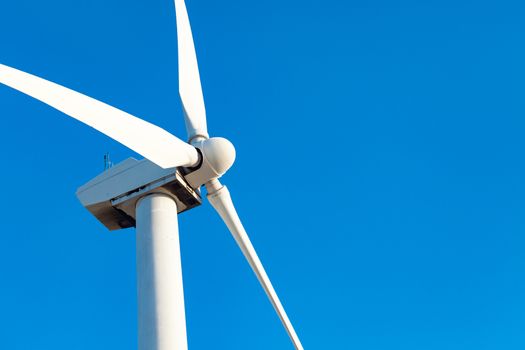 Single Wind Turbine Over Dramatic Blue Sky.