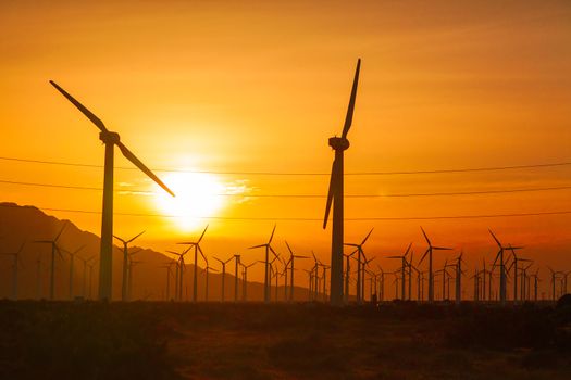 Silhouetted Wind Turbines Over Dramatic Sunset Sky.