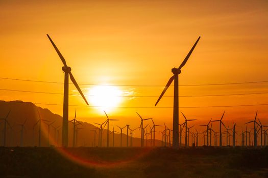 Silhouetted Wind Turbines Over Dramatic Sunset Sky.