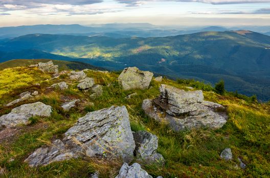 mountain landscape. stones in the grass on the hillside going into the distance under a blue sky