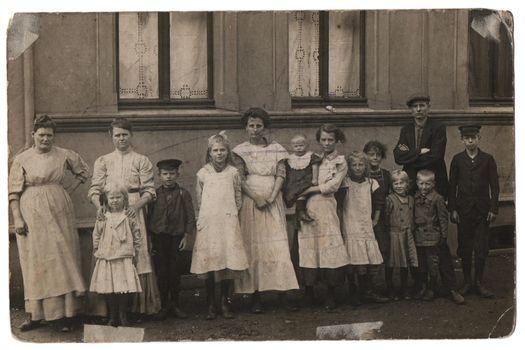 Old family photo in black and white
Parents with eleven children in front of a house. Old family photo around 1885, black and white shot in retro style.