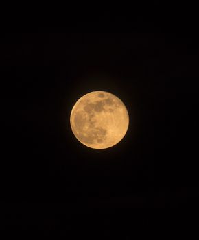 Blue Moon rising on 31 March 2018, portrait orientated image with Moon isolated on black background with text or copy space.