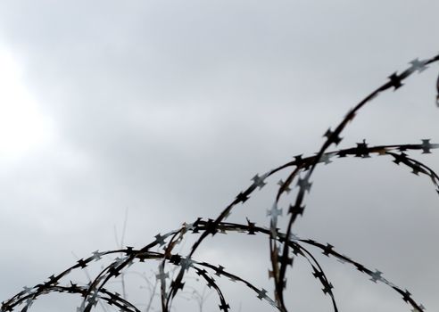 Barbed wire at the cloudy sky.Located in the right corner.