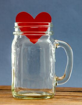 Paper heart inside  jar with blue background