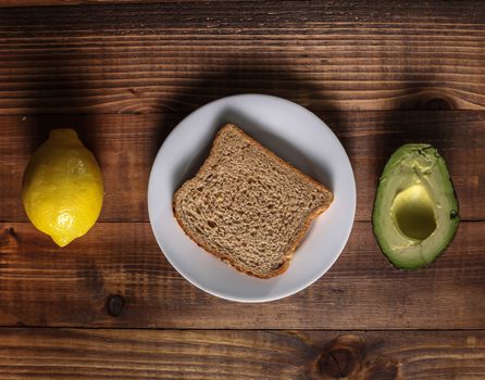 Table with lemon, avocado and bread