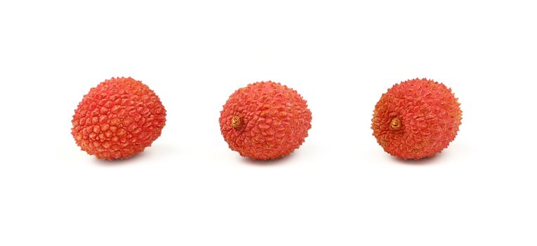 Three fresh red ripe lychee (Litchi chinensis) tropical fruits isolated on white background, detail close up in different perspectives, low angle view