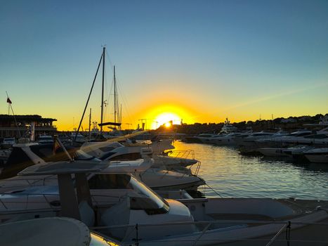 wonderful sunset at the pier with sailboats in front