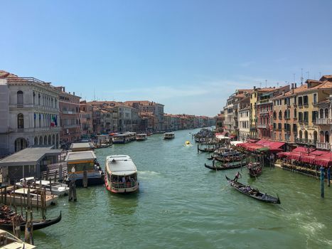 venice canal with boats and gondoliers in the middle