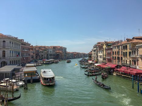 venice canal with boats and gondoliers in the middle