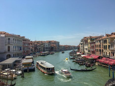 venice canal with boats and gondoliers in the middle