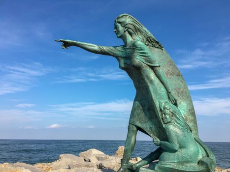 a statue at a beach in venice is showing the way