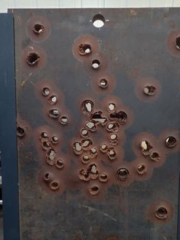 a steel wall with lots of bullets holes in a museum