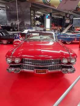 a red cadillac from the fifites in a museum