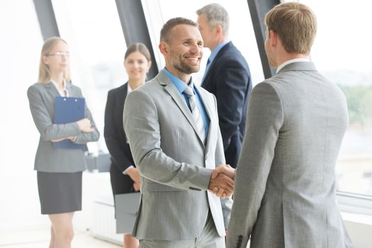 Business people shaking hands, finishing up a meeting in office