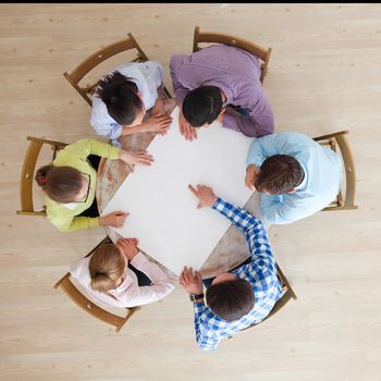 Hipster business teamwork brainstorming planning meeting concept, people team sitting around the table with white paper and pointing, copy space