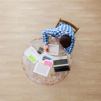 Businessman working with finance documents at office with laptop, and graph data papers on his desk, top view with copy space