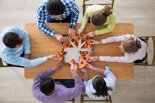 People hands grabbing pizza from delivery box, top view