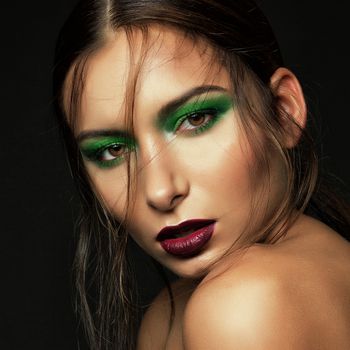 dark portrait cute brunette girl with green makeup