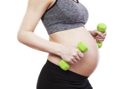 Young pregnant woman practicing fitness. Isolated on white background